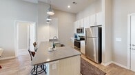 Located at 2051 Establishment Way in Charlotte, NC, this well-appointed single-floor residence combines modern design with functional living spaces. The open-concept kitchen serves as a central hub, featuring stainless steel appliances, white cabinetry, quartz countertops, a peninsula island with bar seating, and pendant lighting — ideal for both cooking and entertaining. The living area is highlighted by luxury vinyl plank flooring, soaring ceilings, and expansive windows with transom accents that flood the space with natural light and offer outdoor views. The primary bedroom is generously sized with plush carpeting, elevated ceilings, and large windows. Its en-suite bathroom includes a glass-enclosed tiled shower, dual-sink vanity with white countertops, and a walk-in closet. Additional bedrooms feature corner window configurations that maximize natural light, also with soft carpet flooring. A secondary bathroom provides a tiled tub-shower combo, wood-look flooring, and a single vanity. Neutral warm tones and clean white trim are consistent throughout, creating a cohesive and contemporary aesthetic. The layout flows efficiently across its single floor, offering comfortable, well-lit spaces suited for everyday living in the Charlotte area.