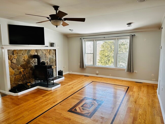 Large, bright living room w/wood burning stove & mounted smart tv - 5 Greenwich Dr