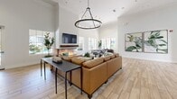 Located at 801 E Atherton Dr in Manteca, California, this single-story community clubhouse offers a well-appointed and thoughtfully designed floor plan ideal for gathering, entertaining, and collaboration. The welcoming entrance features soaring ceilings, light wood-look tile flooring, slatted window shutters, and a striking geometric wood wall accent, setting an elegant tone throughout.

The kitchen is outfitted with rich wood-grain cabinetry, full stainless steel appliances including a refrigerator, range, microwave, and dishwasher, complemented by white quartz countertops, a subway tile backsplash, open floating shelves, and a spacious island — a fully functional space suited for catering or community use.

The dining room features soaring ceilings with crown molding, light-filled French doors leading outdoors, warm wood flooring, and a large communal table, creating an inviting atmosphere for shared meals. A hallway lined with curated artwork and lush greenery connects the various spaces seamlessly.

Multiple living areas serve distinct purposes: one functions as a dedicated theater room with tiered seating, plush sofas, and a ceiling-mounted projector, while another offers a relaxed lounge with deep blue sofas and warm wall sconces. A conference room with a walnut table, green velvet chairs, and a wall-mounted display screen rounds out this versatile and well-designed clubhouse.