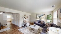 Located at 201 Queensbury Dr in Huntsville, AL, this single-story home offers a thoughtfully arranged layout comprising two bedrooms, two bathrooms, a living room, dining room, kitchen, and hallway. The living room is a welcoming space featuring hardwood-style flooring and multiple windows that allow abundant natural light to fill the room. The kitchen is outfitted with white cabinetry, countertops, and white appliances including a refrigerator, dishwasher, and electric range, with a window above the sink providing additional natural light and hardwood-style flooring underfoot. The dining room features the same warm flooring, a ceiling fan with light fixture, and a comfortable, intimate atmosphere well-suited for everyday meals. The primary bedroom is generously sized with plush carpet, louvered bi-fold closet doors, a ceiling fan, and windows overlooking the outdoors. The second bedroom also features carpet, dual closets, a ceiling fan, and natural light. Both bathrooms include tiled tub-and-shower combinations. The overall ambiance of the home is clean, neutral, and functional, with consistent finishes throughout that create a cohesive and livable environment.