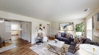 Located at 201 Queensbury Dr in Huntsville, AL, this single-story home offers a thoughtfully arranged layout comprising two bedrooms, two bathrooms, a living room, dining room, kitchen, and hallway. The living room is a welcoming space featuring hardwood-style flooring and multiple windows that allow abundant natural light to fill the room. The kitchen is outfitted with white cabinetry, countertops, and white appliances including a refrigerator, dishwasher, and electric range, with a window above the sink providing additional natural light and hardwood-style flooring underfoot. The dining room features the same warm flooring, a ceiling fan with light fixture, and a comfortable, intimate atmosphere well-suited for everyday meals. The primary bedroom is generously sized with plush carpet, louvered bi-fold closet doors, a ceiling fan, and windows overlooking the outdoors. The second bedroom also features carpet, dual closets, a ceiling fan, and natural light. Both bathrooms include tiled tub-and-shower combinations. The overall ambiance of the home is clean, neutral, and functional, with consistent finishes throughout that create a cohesive and livable environment.