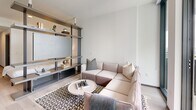 Located at 915 Division St in Nashville, Tennessee, this contemporary one-bedroom, one-bathroom residence offers a thoughtfully designed open-concept layout with modern finishes throughout. Light hardwood flooring flows seamlessly across the entire space, complementing the clean white walls and creating a bright, cohesive aesthetic.

The combined kitchen and living area serves as the heart of the home. The kitchen is outfitted with dark, textured cabinetry, stainless steel appliances including a French door refrigerator, electric range, microwave, and dishwasher, all set against a classic white subway tile backsplash with light countertops. A dining area sits adjacent, providing an intimate space for meals.

The living room is anchored by a striking open steel-and-wood shelving unit that doubles as an entertainment center, adding an industrial-modern design element. Floor-to-ceiling windows flood the space with natural light and frame sweeping views of the Nashville skyline.

A hallway lined with dark-trimmed doors leads to the generously sized primary bedroom, which comfortably accommodates a large bed and features ample natural light and access to the full bathroom.

The bathroom is finished with large-format light tile walls, hexagonal floor tile, a glass-enclosed shower, and matte black fixtures, offering a clean and contemporary spa-like experience.