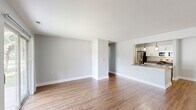 Located at 100 Lake Village Blvd in Auburn Hills, Michigan, this single-floor residence offers a thoughtfully arranged layout comprising two bedrooms, two bathrooms, a combined dining room and kitchen, a living room, an entrance, a hallway, dedicated laundry, and four closets. Rich wood-style flooring flows consistently throughout the main living areas, creating a warm and cohesive aesthetic.

The open living room is bright and spacious, with neutral gray walls and clean white baseboards that lend a modern, move-in-ready feel. It connects seamlessly to the kitchen via a pass-through counter, enhancing the open-concept flow. The galley-style kitchen is well-appointed with white shaker cabinetry, granite countertops, stainless steel appliances, and a double basin sink. The dining area features natural light from a window and is accented by a stylish pendant light fixture.

The primary bedroom is generously sized and includes a built-in closet organizer with dual hanging rods and shelving. The second bedroom also features ample space and hardwood-style flooring. The bathrooms are finished with granite vanity countertops and white cabinetry. Additional storage is abundant throughout, including a large walk-in style closet with extensive shelving. The laundry area includes built-in shelving and an electrical panel for added convenience.