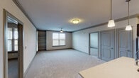 This single-floor residence offers a thoughtfully designed layout that balances comfort and functionality throughout. The spacious living area is finished with plush carpeting and features ceiling fans, built-in shelving, and multiple windows fitted with blinds that allow for natural light while maintaining privacy. A seamless transition connects the living space to the kitchen and additional rooms via hardwood-style flooring.

The kitchen is well-equipped with rich dark cabinetry, light quartz countertops, stainless steel appliances including a range and over-the-range microwave, and a tasteful subway tile backsplash. Track lighting overhead adds both style and practicality to the culinary space.

The unit includes multiple bedrooms, each carpeted and outfitted with ceiling fans and windows that bring in natural light. The primary suite features an en-suite bathroom with a dual-sink vanity topped with quartz counters, dark wood cabinetry, a glass-enclosed shower, and direct access to a spacious walk-in closet. A second full bathroom offers a single-sink vanity and a tub-shower combination, finished with the same warm hardwood-style flooring found throughout the wet areas.

Crown molding accents and neutral tones throughout lend the space a clean, cohesive aesthetic well-suited for comfortable everyday living.