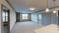 This single-floor residence offers a thoughtfully designed layout that balances comfort and functionality throughout. The spacious living area is finished with plush carpeting and features ceiling fans, built-in shelving, and multiple windows fitted with blinds that allow for natural light while maintaining privacy. A seamless transition connects the living space to the kitchen and additional rooms via hardwood-style flooring.

The kitchen is well-equipped with rich dark cabinetry, light quartz countertops, stainless steel appliances including a range and over-the-range microwave, and a tasteful subway tile backsplash. Track lighting overhead adds both style and practicality to the culinary space.

The unit includes multiple bedrooms, each carpeted and outfitted with ceiling fans and windows that bring in natural light. The primary suite features an en-suite bathroom with a dual-sink vanity topped with quartz counters, dark wood cabinetry, a glass-enclosed shower, and direct access to a spacious walk-in closet. A second full bathroom offers a single-sink vanity and a tub-shower combination, finished with the same warm hardwood-style flooring found throughout the wet areas.

Crown molding accents and neutral tones throughout lend the space a clean, cohesive aesthetic well-suited for comfortable everyday living.