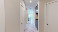 Located at 410 E 7th St in Frederick, Maryland, this efficiently designed unit offers a thoughtfully planned single-floor layout that maximizes every square foot. Light gray luxury vinyl plank flooring runs throughout, lending a clean, cohesive look that ties each space together.

A bright hallway with recessed lighting and crisp white walls provides access to the unit's various rooms, including two closets and a dedicated utility room. The in-unit laundry adds a layer of everyday convenience.

The open-concept kitchen and living area serves as the heart of the unit. The kitchen is outfitted with light wood cabinetry, dark countertops, a tile backsplash, and a full suite of stainless steel appliances including a refrigerator, electric range, microwave, and dishwasher. A pendant light fixture anchors the dining area, while a large window invites natural light and frames views of surrounding greenery.

The bathroom features a tiled tub-shower combination with brushed nickel fixtures, complemented by neutral tile flooring and a clean, modern vanity. Throughout the unit, the neutral color palette, modern hardware, and abundant natural light create a bright and functional living environment.