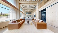 Located at 394 West Ave in Norwalk, CT, this generously scaled single-floor space makes an immediate impression with its soaring double-height ceilings and exposed mass timber framing that define its architectural identity. Floor-to-ceiling windows flood the expansive living area with abundant natural light while offering views of the surrounding streetscape, creating a bright and airy atmosphere anchored by polished concrete floors throughout.

The main living area is a standout feature, designed to accommodate multiple seating arrangements with a sense of openness and flow. A terrazzo-clad island with bar seating serves as a social hub, complemented by open wood shelving and a refined kitchenette finished in dramatic matte black cabinetry, a textured tile backsplash, and integrated appliances.

A dedicated library lounge offers a striking contrast, with dark ceiling treatments, floor-to-wall built-in shelving, and intimate ambient lighting that create a moody, sophisticated retreat. A children's playroom is thoughtfully designed with natural wood built-ins, a pegboard feature wall, and a whimsical teepee, providing a bright and engaging space for younger occupants.

The bedroom provides a more private sanctuary within the layout. Throughout the space, the interplay of warm natural wood, polished concrete, and carefully curated finishes establishes a cohesive modern aesthetic that is both functional and visually compelling.