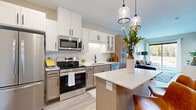Located at 6470 37th Ave NW in Rochester, MN, this well-appointed one-bedroom, one-bathroom residence offers a cohesive modern design across a single-floor layout. The kitchen is a standout feature, showcasing two-tone cabinetry with crisp white uppers and warm wood-toned lower cabinets, a classic subway tile backsplash, stainless steel appliances including a range, microwave, and dishwasher, and a central island with seating — ideal for casual dining. Pendant lighting adds a polished finishing touch overhead. The open living room is bright and welcoming, with light wood-tone flooring carried throughout the space and a sliding glass door that frames outdoor views and fills the room with natural light. The bedroom is a comfortable retreat featuring a walk-in closet, ceiling fan, and windows that bring in additional natural light. The bathroom offers a clean, contemporary aesthetic with warm wood cabinetry, white quartz countertops, and a framed mirror. Completing the unit is a dedicated in-unit laundry area with a stacked washer and dryer. Throughout, the neutral color palette and modern finishes create a cohesive, move-in-ready environment.