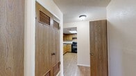 Located in El Paso, TX (79912), this single-story, 2-bedroom, 4-bathroom home offers a well-organized layout designed for comfortable everyday living. The living room serves as the heart of the home, featuring rich hardwood-style flooring, a ceiling fan, and a striking black-tiled wood-burning fireplace flanked by windows that invite natural light. A glass door provides direct outdoor access, enhancing the open feel of the space. The kitchen is equipped with warm honey-toned cabinetry, dark countertops, black appliances including a range, refrigerator, and dishwasher, and a skylight that brightens the room naturally. Light wood-style flooring ties the kitchen seamlessly to the adjoining dining area. A central hallway connects the main living spaces to the bedrooms, with louvered doors leading to closets and additional rooms. The spacious primary bedroom features plush carpeting, large windows with outdoor views, and a generous walk-in closet with dual hanging rods. The secondary bedroom is equally well-appointed with soft carpeting. Four bathrooms provide ample convenience, with at least one featuring a tub-shower combo. A dedicated laundry room and four closets throughout round out this practical and comfortable home.