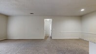 Located at 14231 FM-1464 N in Sugar Land, TX, this single-floor, 2-bedroom, 2-bathroom home offers a well-organized layout with a comfortable mix of finishes and functional spaces. The open-concept living and dining area features plush carpeting and flows directly into the kitchen, which is equipped with white cabinetry, granite-style countertops, a peninsula island with a built-in sink, and black appliances including a refrigerator and range. Wood-look vinyl flooring in the kitchen transitions seamlessly to the carpeted living area. Both bedrooms are carpeted and fitted with ceiling fans, with the primary bedroom offering a generously sized footprint and closet access. The two bathrooms mirror each other in design, each featuring white vanities with granite-style countertops, a tub-shower combination, and wood-look vinyl flooring. A dedicated in-unit laundry room houses a full-size washer and dryer with wire shelving above for additional storage. Two hallways and two closets provide ample circulation and storage throughout. Textured ceilings and clean white walls create a bright, neutral palette across the entire home, lending a move-in-ready aesthetic suited for everyday living.