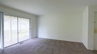 Located at 1844 Forest Village Lane in Columbus, Ohio, this single-floor residence offers a clean, functional layout with a straightforward and practical design. The interior is finished with wall-to-wall carpeting that runs throughout the living areas, providing a warm and comfortable underfoot feel. The walls are painted in a neutral white tone, creating a bright and open atmosphere that allows for easy personalization and décor. A textured ceiling adds subtle dimension to the space. One of the standout features of the main living area is a full-width sliding glass door that floods the room with natural light and provides direct access to an outdoor area. Through the glass, greenery and a fenced exterior are visible, offering a pleasant outdoor view and connection to nature. The sliding door setup is ideal for easy indoor-outdoor flow, making the space feel more expansive than its footprint might suggest. The overall ambiance of the home is clean, neutral, and move-in ready, well-suited for those seeking a low-maintenance living environment in a residential Columbus neighborhood. The single-floor layout ensures convenient accessibility throughout.