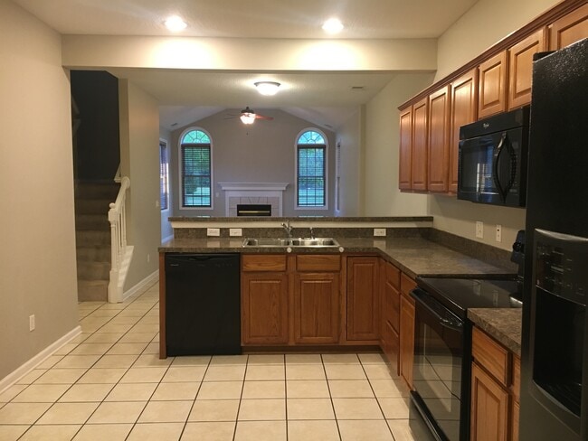 Kitchen/black appliances open to dining and great room - 2833 Riverwalk Blvd