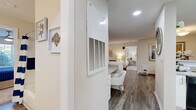 Located at 100 Camellia Ln in Stonecrest, GA, this single-floor residence offers 2 bedrooms and 4 bathrooms within a smartly utilized footprint. The living room serves as the heart of the home, featuring wood-look plank flooring, a ceiling fan, and large windows and glass doors that invite natural light and offer views of the outdoors. The space flows naturally into a dining area, creating a cohesive and welcoming common area.

The kitchen is outfitted with crisp white shaker-style cabinetry, light countertops, and black appliances including a range, dishwasher, and refrigerator, all set atop matching wood-look flooring. The design is both functional and visually clean.

Both bedrooms are carpeted and feature ceiling fans, with the primary bedroom offering a comfortable, well-proportioned retreat alongside a spacious walk-in closet with multi-tiered wire shelving. A second walk-in style closet provides additional storage. The bathrooms are finished with white cabinetry, wide vanity mirrors, and tub-shower combinations, with the primary bath boasting a dual-sink vanity.

Additional conveniences include a dedicated laundry area and well-placed hallways that keep the layout open and accessible. Neutral tones and consistent finishes throughout create a cohesive, move-in-ready aesthetic.