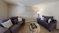 This 2-bedroom, 1-bathroom residence is thoughtfully laid out across a single floor, offering a comfortable and functional living environment. The living room features plush carpeting, neutral-toned walls, and natural light from a window with blinds, creating a welcoming atmosphere for relaxing or entertaining. Adjacent to the living area, the dining space includes a ceiling fan with integrated lighting, a window overlooking the exterior, and direct sightlines to the kitchen, supporting an open and connected flow.

The kitchen is equipped with white cabinetry, a double stainless steel sink with a gooseneck faucet, and laminate countertops, providing ample workspace and storage. A pass-through window connects the kitchen to an adjacent area, enhancing the sense of openness.

Both bedrooms are carpeted and outfitted with ceiling fans. The primary bedroom features two separate closets, offering generous storage capacity. The second bedroom is bright and open, with a window allowing in natural light.

The full bathroom includes a single-sink vanity with a mirror, a toilet, and a shower-tub combination, finished in clean white fixtures with warm-toned walls. Throughout the unit, consistent neutral color palettes and carpet flooring contribute to a cohesive, move-in-ready aesthetic.