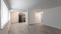This single-floor residence at 617 Adams Dr in Newport News, Virginia offers a practical and well-maintained layout with consistent design choices throughout. The kitchen is a functional highlight, outfitted with rich, dark-toned shaker-style cabinetry accented by brushed nickel hardware and light granite-look countertops. Black appliances — including a refrigerator, range with overhead ventilation, and dishwasher — provide a cohesive, modern aesthetic. Light wood-look luxury vinyl flooring runs continuously through the kitchen and into the adjoining living areas, creating visual continuity across the space.

The open living area is generously proportioned, featuring neutral white walls, a ceiling fan with light fixture, and multiple windows fitted with blinds that allow natural light to fill the room. The layout, as seen in the floor plan, reflects a thoughtful division between living, kitchen, and private sleeping areas.

The bedrooms are comfortably sized, each with its own closet featuring a rod and open shelving. Natural light enters through windows in each room, and the same wood-look flooring extends throughout. The bathroom is finished with a clean white tiled tub-and-shower surround, a built-in niche, and brushed nickel fixtures, maintaining a cohesive and fresh aesthetic across the entire unit.