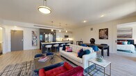 Located on East Sixth Street in the heart of downtown Cleveland, this contemporary residence offers a thoughtfully designed single-floor layout with modern finishes throughout. The open-concept living, dining, and kitchen area serves as the centerpiece of the space, featuring light wood-look flooring, recessed lighting, and a bold pendant fixture that anchors the room. Large windows frame sweeping views of the Cleveland skyline and Lake Erie beyond, flooding the living area with natural light.

The kitchen is outfitted with two-tone cabinetry — dark lower cabinets paired with high-gloss white upper cabinets — complemented by a light quartz countertop, a stainless steel appliance suite, and a kitchen island with bar seating. The layout flows seamlessly into the living and dining areas, making the space ideal for both everyday living and entertaining.

Two well-proportioned bedrooms each offer access to natural light, with one featuring a floor-to-ceiling window showcasing city views. Both bathrooms maintain a clean, minimalist aesthetic with dark wood-look tile flooring, warm wood vanities, and tub-shower combinations. The entry foyer provides a smooth transition into the open living areas, completing a well-organized and stylish urban residence.
