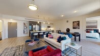 Located on East Sixth Street in the heart of downtown Cleveland, this contemporary residence offers a thoughtfully designed single-floor layout with modern finishes throughout. The open-concept living, dining, and kitchen area serves as the centerpiece of the space, featuring light wood-look flooring, recessed lighting, and a bold pendant fixture that anchors the room. Large windows frame sweeping views of the Cleveland skyline and Lake Erie beyond, flooding the living area with natural light.

The kitchen is outfitted with two-tone cabinetry — dark lower cabinets paired with high-gloss white upper cabinets — complemented by a light quartz countertop, a stainless steel appliance suite, and a kitchen island with bar seating. The layout flows seamlessly into the living and dining areas, making the space ideal for both everyday living and entertaining.

Two well-proportioned bedrooms each offer access to natural light, with one featuring a floor-to-ceiling window showcasing city views. Both bathrooms maintain a clean, minimalist aesthetic with dark wood-look tile flooring, warm wood vanities, and tub-shower combinations. The entry foyer provides a smooth transition into the open living areas, completing a well-organized and stylish urban residence.