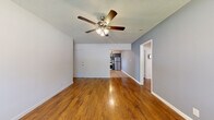 Located on Venice Boulevard in Los Angeles, this 2-bedroom, 1-bathroom single-story home offers a well-organized layout with consistent finishes throughout. Rich hardwood flooring runs across the living room, bedrooms, and hallway, creating a warm, cohesive aesthetic. The living room is a generously proportioned space featuring cool blue-gray walls, a textured ceiling, a ceiling fan with integrated lighting, and a window that brings in natural light. It connects seamlessly to the kitchen and hallway, promoting an open flow. The kitchen stands out as a highlight of the home, appointed with dark gray cabinetry featuring gold hardware, a mosaic tile backsplash, white countertops, and a full suite of stainless steel appliances including a gas range, over-the-range microwave, dishwasher, and refrigerator. Light wood-tone flooring completes the contemporary kitchen aesthetic. The primary bedroom is a comfortable, well-lit retreat with dual windows, blue-gray accent walls, a ceiling fan, and a wall-mounted HVAC unit. The second bedroom mirrors a similar design. The hallway leads to a shared full bathroom finished in clean white tones, featuring a shower-tub combination, toilet, vanity with storage, and a frosted privacy window.