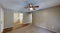 Located at 2319 College Dr in Phenix City, Alabama, this single-floor, 2-bedroom, 2-bathroom home offers a functional and well-organized layout. The living room serves as the heart of the home, featuring plush carpeting, a ceiling fan with light fixture, and French doors that invite natural light and provide outdoor access. An open sightline connects the living area to the kitchen, enhancing the sense of space.

The galley-style kitchen is efficiently designed with white cabinetry lining both sides, light-toned countertops, a double sink, a white electric range, and a full-size refrigerator. Wood-look flooring runs throughout the kitchen and dining area, adding warmth and easy maintenance.

Both bedrooms are carpeted and equipped with ceiling fans. The primary bedroom offers a comfortable footprint with a dedicated closet, while the second bedroom also benefits from natural light and access to additional closet space. A hallway connects the bedrooms to the two bathrooms, each featuring wood-look flooring, a white vanity with under-sink storage, a wall mirror with overhead lighting, and a tub-shower combination. The home also includes a dedicated laundry area and a utility room, completing its practical and livable layout.