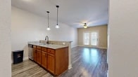 Located at 210 S Locust St in Denton, TX, this single-story, one-bedroom, one-bathroom unit offers a thoughtfully designed layout that maximizes its cozy footprint. The open-concept kitchen and living area serves as the heart of the home, anchored by a peninsula breakfast bar topped with granite countertops and illuminated by pendant lighting. The kitchen is equipped with warm wood cabinetry, a tile backsplash, and a full suite of stainless steel appliances, including a refrigerator and microwave. The living area flows seamlessly from the kitchen, featuring durable wood-look flooring, a ceiling fan, and a set of French doors that invite natural light and provide outdoor access. The bedroom is a comfortable retreat finished with plush carpeting, dual windows with blinds that offer ample natural light and exterior views, and a ceiling fan for year-round comfort. A dedicated closet provides convenient storage. The bathroom is clean and functional, featuring a tiled tub-shower combination with matte black fixtures and wood-look flooring that ties in with the rest of the unit. Neutral warm-toned walls and crisp white trim throughout lend the space a bright, cohesive aesthetic.
