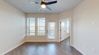 Located in Apopka, Florida, this well-appointed single-story home offers three bedrooms and two bathrooms within a thoughtfully designed floor plan. Wood-look plank flooring runs throughout the main living areas, lending warmth and cohesion to the space.

The open kitchen is a standout, featuring two-tone cabinetry — crisp white uppers paired with light grey lowers — complemented by white quartz countertops, a herringbone tile backsplash, and a full suite of stainless steel appliances including a refrigerator, electric range, and microwave. The adjoining living room is bright and spacious, offering a clean, neutral palette ideal for a variety of furnishing styles.

Each bedroom is filled with natural light through blinded windows, and ceiling fans provide year-round comfort. The bedrooms offer views of the surrounding greenery, enhancing the sense of openness. The primary bedroom is generously sized and features a walk-in closet equipped with wire shelving for ample storage.

The two bathrooms are finished with large-format light grey tile. The primary bath features a sleek glass-enclosed walk-in shower with a rain showerhead and matte black hardware, while the second bath offers a full soaking tub with matching matte black fixtures. A connecting hallway ties all rooms together efficiently, completing this clean and modern home.