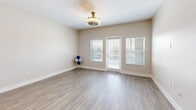 Located at 26000 W Lugonia Ave in Redlands, CA, this well-appointed one-bedroom, one-bathroom residence offers a thoughtfully designed layout across a single floor. The open-concept living and kitchen area forms the heart of the home, featuring warm wood-style flooring, neutral walls, and a decorative ceiling fixture that adds a refined touch. Natural light flows in through windows dressed with clean white blinds, and a private door provides outdoor access directly from the living space.

The kitchen is a standout feature, showcasing rich dark cabinetry, a full suite of stainless steel appliances including a gas range, microwave, dishwasher, and refrigerator, and a crisp white quartz-topped island with seating for two — ideal for casual dining or entertaining. Pendant lighting above the island adds a modern finishing detail.

The bedroom is carpeted for comfort and includes a window with natural views, a ceiling vent for climate control, and access to a generous walk-in closet with dual hanging rods and shelving on multiple walls for ample storage.

The bathroom features a full tub-shower combo with white subway tile surround, chrome fixtures, a dark wood medicine cabinet, and wood-look tile flooring. A connecting hallway ties all areas together efficiently, completing this clean, modern residence.