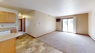 Located at 1017 41st St NW in Rochester, Minnesota, this single-floor, 3-bedroom, 2-bathroom home offers a practical and comfortable layout. The living area serves as the heart of the home, featuring a combination of tile and carpet flooring, a ceiling fan, a textured ceiling, and a sliding glass door that fills the space with natural light and provides outdoor access. The kitchen is efficiently arranged with warm maple cabinetry, a tile floor, and white appliances including a range, dishwasher, and refrigerator, complemented by a double sink and ample counter space. Three carpeted bedrooms provide comfortable retreats, each featuring sliding or hinged wood-trimmed windows that invite natural light. The primary bedroom includes a closet with sliding mirrored doors, while additional bedrooms offer closet space and baseboard heating. A hallway connects the bedrooms to the two bathrooms, one of which features a tub-shower combination with tile flooring and a vanity with built-in drawers. Warm wood-tone door frames and trim are consistent throughout, lending a cohesive and tidy aesthetic to the entire home.
