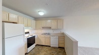 Located at 2801 Montaluma Dr in Springfield, Illinois, this single-floor unit offers a practical and comfortable layout designed for everyday living. The open living and dining area is finished with neutral carpeting and features a ceiling fan with light fixture, creating a bright and airy atmosphere. A sliding glass door leads to a private balcony, allowing natural light to flow freely into the main living space.

The kitchen is well-appointed with light wood cabinetry offering generous storage, a double sink, electric range, refrigerator, and dishwasher. The distinctive stone-tile flooring adds visual interest and durability to the kitchen and bathroom areas, providing a natural contrast to the soft carpeting throughout the rest of the unit.

The bedrooms are comfortably sized, each carpeted and featuring windows with blinds that bring in natural light. The primary bedroom includes a ceiling fan and a closet with bifold doors. Additional bedrooms are well-proportioned with clean, neutral walls suited for a variety of uses.

The bathroom continues the stone-tile flooring theme and is accessed through a hallway with louvered closet doors nearby. Textured ceilings are consistent throughout the unit, complementing the clean, understated aesthetic. Overall, this unit presents a functional and well-maintained living space in Springfield, IL.