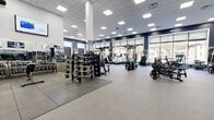 Located at 744 Newark Ave in Elizabeth, NJ, Grand Luxury Fitness Center & Spa is a expansive, single-floor fitness facility designed to deliver a premium workout experience. The open-plan layout provides ample room for a wide variety of equipment zones, creating a well-organized and comfortable environment for members of all fitness levels.

The facility features a robust strength training area outfitted with cable machines, multi-functional cable systems, weight racks stocked with EZ curl bars and dumbbells, plate-loaded equipment, and a dedicated free weights zone with rubber flooring for safety. A separate turf area provides space for functional training and dynamic exercises.

The cardio section is equally well-appointed, featuring treadmills with personal monitors, elliptical machines, stationary bikes, and air bikes—all positioned along large street-facing windows that flood the space with natural light and offer views of the surrounding neighborhood.

Throughout the facility, motivational wall graphics and flat-screen TVs contribute to an energizing atmosphere. The drop-panel ceiling with recessed LED lighting ensures bright, even illumination across the entire floor. Full-length mirrors line multiple walls, enhancing the sense of openness. The durable speckled rubber flooring provides both comfort and functionality, rounding out this well-equipped fitness destination.