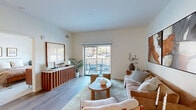 Located at 1619 N Neva Ave in Chicago's Galewood neighborhood, this 2-bedroom, 1-bathroom unit offers a thoughtfully designed single-floor layout with modern finishes and a warm, contemporary aesthetic. The open-concept kitchen and living area serves as the heart of the home, featuring a generously sized island with a quartz countertop and built-in sink, light wood cabinetry extending to the ceiling, stainless steel appliances including a French door refrigerator and electric range, and stylish pendant lighting overhead. Wood-look flooring runs throughout the main living areas, adding warmth and continuity. The living room is bright and inviting, with sliding glass doors that open directly onto a private balcony overlooking the outdoors, allowing natural light to pour in. A hallway leads to both bedrooms, each featuring plush carpeting, windows with exterior views, and clean white walls. The primary bedroom offers a comfortable footprint with ample natural light. The bathroom is finished with light tile flooring, a shower-tub combination with glass enclosure, and a clean, neutral palette. A dedicated entryway area with hardwood-style flooring provides a graceful transition into the living spaces, completing this well-appointed urban residence.