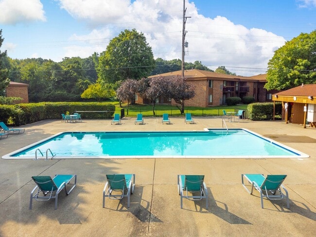 Heated pool equipped with comfy lounge chairs at Westwood Village Apartments in Westland, MI - Westwood Village Apartments