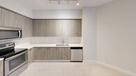 This contemporary apartment in Palmetto Bay, FL offers 560 square feet of thoughtfully designed living space. The unit features two bedrooms, including a primary bedroom of 130 square feet, and one bathroom. The modern kitchen is a highlight, boasting sleek wood-grain cabinetry, quartz countertops, and stainless steel appliances including a side-by-side refrigerator, built-in microwave, and electric range.

The open-concept layout maximizes the use of space, with the kitchen flowing seamlessly into the living area. Large windows in the bedrooms allow for ample natural light, creating a bright and airy atmosphere. The bathroom features a spacious vanity with a large mirror and modern fixtures.

Practicality meets style with in-unit laundry facilities, providing added convenience. The neutral color palette throughout the apartment, combined with tile flooring, offers a clean and versatile backdrop for various decor styles. Track lighting in the kitchen adds a contemporary touch while providing functional task lighting.

Despite its compact size, the apartment's clever design ensures each space is utilized efficiently, making it an ideal choice for those seeking a low-maintenance yet stylish living environment in the desirable Palmetto Bay area.