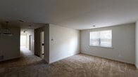 Located at 26 Cheswold Blvd in Newark, Delaware, this single-floor unit offers five bedrooms and two bathrooms across a well-utilized footprint. The layout is efficiently organized, with a central hallway connecting the living areas to the bedrooms and bathrooms.

The living area features neutral-toned carpet and a large window that allows natural light to fill the space. A glimpse of the kitchen is visible from the main living area, creating a connected feel. The kitchen is well-appointed with white cabinetry, dark granite-style countertops, a stainless steel sink, a dishwasher, an electric range, and a window overlooking the exterior.

The bedrooms are carpeted throughout, each featuring neutral walls, standard windows with blinds, and clean white trim. The spacious primary bedroom offers generous room for furnishings and includes closet access. Additional bedrooms are similarly finished, providing comfortable and functional spaces.

The two bathrooms feature tile flooring. One bathroom includes a walk-in glass-enclosed shower stall, while the other is equipped with a vanity featuring dark countertops and white cabinetry. Both bathrooms are fitted with standard fixtures. Overall, the unit presents a clean, straightforward design well-suited for multi-occupant living.