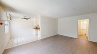 Located at 8825 Woodman Ave in Arleta, CA, this one-bedroom, one-bathroom unit offers a thoughtfully laid-out single-floor plan. The open living and dining area is finished with light wood-look flooring and a textured ceiling, while a ceiling fan provides year-round comfort. Large sliding glass doors and windows dressed with vertical blinds allow natural light to fill the space, creating a bright and airy atmosphere. A wall-mounted AC unit serves the living area for additional climate control.

The galley-style kitchen features white cabinetry, granite-look countertops, white tile flooring, and includes a refrigerator and electric range, making efficient use of its layout. An adjacent dining area connects seamlessly to the main living space.

The spacious primary bedroom offers wood-look flooring, a ceiling fan, and a window with outdoor views, along with a well-organized closet featuring built-in shelving and sliding mirror doors. An additional closet provides extra storage along the hallway.

The bathroom is clean and functional, showcasing a tiled tub-shower combination with white subway tiles, a granite-topped vanity, and a window above the tub that invites natural light. A connecting hallway ties all rooms together in a cohesive, easy-to-navigate layout.