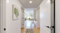 Located at 4832 S Newport St in Denver, Colorado, this one-bedroom, one-bathroom unit offers a thoughtfully designed layout that maximizes every square foot across a single floor. Light hardwood flooring flows throughout the space, creating a cohesive and bright aesthetic.

The combined kitchen and living area serves as the heart of the unit. The kitchen features flat-front cabinetry in a warm wood-grain finish, stainless steel appliances including a gas range, dishwasher, refrigerator, and microwave, along with a slate-blue subway tile backsplash and dark countertops. The living area benefits from large windows that invite natural light and offer views of the surrounding urban environment, with an exposed concrete structural column adding an industrial design element.

A hallway connects the living space to the private areas of the unit, with framed artwork adorning the white walls. The bedroom is an intimate, cozy space outfitted with a ceiling fan and warm-toned lighting. A dedicated closet provides storage.

The bathroom features wood-grain cabinetry, a dark undermount sink, a large mirror, wall-mounted storage, and a shower-tub combination with white tile surround, all set on matching light hardwood flooring.