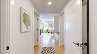 Located at 4832 S Newport St in Denver, Colorado, this one-bedroom, one-bathroom unit offers a thoughtfully designed layout that maximizes every square foot across a single floor. Light hardwood flooring flows throughout the space, creating a cohesive and bright aesthetic.

The combined kitchen and living area serves as the heart of the unit. The kitchen features flat-front cabinetry in a warm wood-grain finish, stainless steel appliances including a gas range, dishwasher, refrigerator, and microwave, along with a slate-blue subway tile backsplash and dark countertops. The living area benefits from large windows that invite natural light and offer views of the surrounding urban environment, with an exposed concrete structural column adding an industrial design element.

A hallway connects the living space to the private areas of the unit, with framed artwork adorning the white walls. The bedroom is an intimate, cozy space outfitted with a ceiling fan and warm-toned lighting. A dedicated closet provides storage.

The bathroom features wood-grain cabinetry, a dark undermount sink, a large mirror, wall-mounted storage, and a shower-tub combination with white tile surround, all set on matching light hardwood flooring.