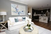 This well-appointed single-floor residence offers two bedrooms and two bathrooms across a generously sized, thoughtfully designed layout. The living room serves as a welcoming centerpiece, featuring crown molding, hardwood-style flooring, a ceiling fan, and large windows with direct access to an outdoor area, filling the space with natural light and an airy ambiance.

The kitchen is a standout feature, outfitted with rich, dark cabinetry extending to the ceiling, granite countertops, a full suite of stainless steel appliances—including a range, microwave, dishwasher, and refrigerator—and a peninsula with pendant lighting that provides additional seating and prep space.

Both bedrooms are carpeted and comfortably sized, each offering access to a dedicated bathroom. The primary bathroom features a dual-sink vanity with granite countertops, dark cabinetry, hardwood-style flooring, and a glass-enclosed shower. The second bathroom mirrors the same design aesthetic with granite countertops and dark cabinetry, and includes a full soaking tub with a shower. Neutral tones and consistent finishes throughout the residence create a cohesive, modern aesthetic.