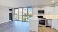 Located on the fifth floor at 235 Bloor Street East in Toronto's vibrant Bloor-Yorkville neighbourhood, this one-bedroom, one-bathroom unit offers a thoughtfully designed layout that maximizes every inch of its compact footprint. The open-concept living and kitchen area is anchored by expansive floor-to-ceiling windows that flood the space with natural light and frame views of the surrounding cityscape and greenery below. Light hardwood-style flooring runs throughout, lending warmth and continuity to the interior. The modern kitchen features sleek white cabinetry, a white quartz peninsula, and a full suite of stainless steel appliances including a gas range, built-in microwave, and refrigerator — ideal for everyday cooking and entertaining. Recessed lighting complements the natural light throughout. The bedroom is a calm retreat, finished with the same light flooring and fitted with mirrored sliding closet doors that reflect natural light from the window. The bathroom is finished with neutral tile flooring, white wall tiles, a vanity with storage, and a full bathtub with shower. Clean lines and a neutral colour palette throughout give the unit a fresh, contemporary feel well-suited to urban living in one of Toronto's most walkable and sought-after neighbourhoods.