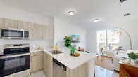 Located at 1150 SW 70th Ave in Miami, FL, this well-appointed 2-bedroom, 2-bathroom residence offers a thoughtfully designed single-floor layout with modern finishes throughout. The open-concept living and dining area flows seamlessly into a fully equipped kitchen, which features light wood cabinetry, white quartz countertops, stainless steel appliances including a refrigerator, range, and microwave, and a peninsula with bar seating — ideal for both cooking and entertaining. Gleaming large-format tile flooring runs throughout the space, enhancing the bright, airy atmosphere created by white walls and ample natural light. A sliding glass door leads to a private balcony overlooking the surrounding neighborhood. Both bathrooms are finished with light wood vanities, white countertops, and tub-shower combinations. The primary bedroom includes direct access to its own bathroom and features generous closet space. The secondary bedroom is bright and comfortable, with a window providing natural light and outdoor views. Additional highlights include three closets, an in-unit laundry area, and two hallways connecting the space efficiently. This residence combines clean, contemporary design with practical functionality in a vibrant Miami location.