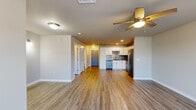 Located at 1130 Alexandra Ln in Harrisburg, PA, this single-floor unit offers a well-designed layout that makes efficient use of its space. The open-concept living area is finished with durable wood-style luxury vinyl flooring that flows consistently throughout, lending a cohesive and clean aesthetic. A ceiling fan with a light fixture provides both comfort and illumination, while a window allows natural light to brighten the room. A closet with louvered doors adds practical storage directly within the living space.

The kitchen is a standout feature, showcasing crisp white shaker-style cabinetry with brushed nickel hardware, dark granite countertops, and a striking mosaic tile backsplash in tones of gray, black, and white. Stainless steel appliances—including a refrigerator, gas range with microwave above, and dishwasher—complete the modern, functional setup. Recessed lighting highlights the kitchen's polished finishes.

The bathroom is clean and functional, featuring a full tub and shower combination with white surround panels, brushed nickel fixtures, and wood-style flooring that ties seamlessly to the rest of the unit. Neutral wall tones throughout the space create a calm, move-in-ready atmosphere suited for a variety of uses.