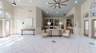 Located at 560 W New Hope Rd in Goldsboro, NC, this single-floor space impresses with its thoughtful design and versatile layout. The main gathering area commands attention with soaring vaulted ceilings, large-format tile flooring, and an abundance of natural light streaming through dramatic arched transom windows and French doors. A ceiling fan anchors the space, while built-in shelving and a fireplace lounge area offer an inviting retreat, complete with classic wainscoting, built-in cabinetry, and a cozy seating arrangement.

The kitchen is efficiently designed with gray raised-panel cabinetry, dark granite countertops, stainless steel appliances, and a functional breakfast bar with seating — all finished with light tile flooring and a bright window. A pass-through counter connects the kitchen seamlessly to the main area, enhancing the open flow of the space.

Dedicated office areas are outfitted with rich, warm-toned wood built-in desks and upper cabinetry, providing ample workspace and storage. French glass-panel doors lead between rooms, maintaining an open and airy feel throughout. The overall ambiance is polished yet welcoming, blending practical functionality with refined architectural details.
