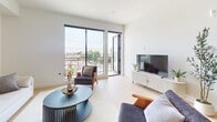 Unit 402 at 806 N Edinburgh Ave is a thoughtfully designed 3-bedroom, 2-bathroom apartment spanning 990 square feet in the heart of West Hollywood, Los Angeles. The open-concept living and dining area is bathed in natural light from floor-to-ceiling black-framed windows and sliding glass doors that lead to a private balcony with sweeping city views. Light hardwood flooring flows throughout, complementing the clean, modern aesthetic. The kitchen features flat-front cabinetry in a warm wood tone, white subway tile backsplash, stainless steel appliances including a full-size refrigerator and dishwasher, and ample counter space. The primary bedroom measures 220 square feet and offers high ceilings, large windows, and generous built-in closet storage. Additional bedrooms are well-proportioned with light-toned built-in wardrobes. The primary bathroom includes a double-sink vanity with wood cabinetry, white quartz countertops, and framed mirrors, while the second bathroom mirrors the same contemporary finishes with a single vanity and clean tile flooring. The unit's bright, neutral palette and modern architectural details create a cohesive, sophisticated living environment.