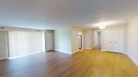 This single-floor residence offers a clean, updated interior with a thoughtful layout designed for comfortable living. The open living and dining area is finished with warm hardwood-style flooring and a textured ceiling, lending a bright and welcoming atmosphere. Vertical blinds on a large sliding door allow for adjustable natural light throughout the main living space.

The kitchen is well-equipped with crisp white shaker-style cabinetry, white quartz countertops, and stainless steel appliances including a dishwasher, range, and refrigerator. Recessed lighting and a window above the sink provide both functionality and natural brightness in this efficiently designed space.

The bedrooms are carpeted in neutral tones and each features a window that brings in natural light and views of the surrounding neighborhood, creating a calm and restful environment. A hallway connects the rooms seamlessly, providing a practical flow throughout the unit.

The bathroom is finished with a white vanity, quartz countertop, a large wood-framed mirror, and contemporary fixtures, offering a clean and modern aesthetic. Additionally, a dedicated laundry room with hookups provides added convenience. Throughout the residence, neutral wall tones and consistent flooring choices create a cohesive and move-in-ready environment.
