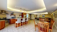 Located on Grandview Avenue in Pittsburgh's Mount Washington neighborhood, this expansive single-floor amenity space offers residents a comprehensive range of recreational and social facilities across a generous footprint. The layout is divided into three distinct areas, each designed to serve a specific purpose while maintaining a cohesive, modern aesthetic throughout.

The social lounge and kitchenette area features a granite-topped breakfast bar with upholstered bar seating, warm wood cabinetry, pendant lighting, and a tray ceiling with subtle ambient uplighting. Vending machines and a full-size refrigerator provide convenient refreshments, while a dining table offers additional seating for gatherings.

Adjacent to the lounge, the game room is well-appointed with a billiards table, ping-pong table, dartboard, and comfortable seating. The room features a mix of tile and carpet flooring, soft wall sconces, and a tray ceiling that continues the refined design language found throughout the space.

The crowning feature is the expansive outdoor pool area, enclosed by a wooden privacy fence and surrounded by a spacious patio deck with lounge chairs. The bright blue pool offers clearly marked depth zones and direct glass-door access to the interior, creating a seamless indoor-outdoor connection. Open skies above the pool area provide an airy, resort-like atmosphere in the heart of Pittsburgh.