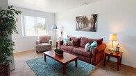This two-story home offers a practical and comfortable layout across two levels. The living room serves as the central gathering space, featuring neutral-toned carpet, bright walls, and a window that brings in natural light with views of the surrounding outdoors. A staircase connects the main level to the upper floor, adding a sense of dimension to the layout.

The kitchen is designed for functionality, featuring dark wood cabinetry that extends to the ceiling, white appliances including a gas range and dishwasher, and a ceiling fan overhead. A small dining area adjacent to the kitchen provides a convenient space for casual meals.

Both bedrooms are carpeted and well-proportioned, each offering windows that let in natural light. The primary bedroom includes dual closets, providing generous storage. The second bedroom features a standard closet and a charming, cozy atmosphere.

The full bathroom is neatly appointed with a vanity, tile flooring, and a shower-tub combination. A half bathroom on another level offers added convenience for daily living. Throughout the home, the light-colored walls and carpeted floors create a clean, consistent aesthetic.