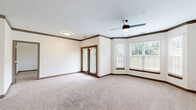 Located at 1402 Crazy Horse Lane in Middletown, KY, this 2-bedroom, 2-bathroom unit offers a well-designed single-floor layout with a thoughtful mix of comfort and modern finishes. The open-concept kitchen and living area serves as the heart of the home, featuring a large granite-topped island with an undermount sink, dark espresso cabinetry, a subway tile backsplash, stainless steel appliances, and recessed lighting. Light hardwood-style flooring grounds the kitchen, which flows seamlessly into the carpeted living area. The living room is highlighted by a charming bay window that floods the space with natural light, complemented by a ceiling fan and elegant crown molding with dark wood accents. A set of glass-paneled doors provides additional access to the outdoors. Both bedrooms are carpeted and well-sized, with the primary bedroom offering generous proportions and ample closet space. The unit includes an impressive six closets in total, including a spacious walk-in equipped with wire shelving. The two bathrooms are finished with granite countertops and dark cabinetry; one features a dual-sink vanity with framed mirrors, while the other includes a soaking tub with a white subway tile surround. An in-unit laundry area and a connecting hallway round out this functional and attractively appointed home.