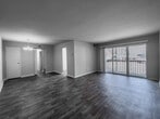 This single-floor residence offers a thoughtfully designed layout that balances comfort and functionality. The spacious living area is a highlight of the home, featuring wood-style flooring and a large sliding glass door that opens to a private balcony, allowing abundant natural light and outdoor views to fill the room. An elegant chandelier illuminates the dining area, which also showcases the same warm wood-style flooring and a clean, neutral color palette that creates a bright and welcoming atmosphere.

The kitchen has been well-equipped with crisp white shaker cabinetry, granite-look countertops, and a full suite of stainless steel appliances, including a gas range, over-the-range microwave, and dishwasher. Light wood-tone flooring ties the kitchen seamlessly into the rest of the living spaces.

Additional areas include a carpeted bedroom zone that offers a softer, quieter environment, complemented by generous closet storage as seen in the floor plan. The bathroom is outfitted with a full soaking tub and shower surround in a clean, neutral finish. Throughout the unit, consistent neutral tones, clean lines, and practical finishes come together to create a move-in-ready space that is both comfortable and easy to personalize.