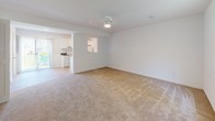 Located at 510 Nottingham Ct in Hopewell, Virginia, this two-floor home offers a straightforward, functional layout across its multiple levels. The main floor features a generously sized living area finished with neutral-toned carpet, ceiling-mounted lighting, and a welcoming front entry door with an adjacent staircase leading to the upper level. The living space flows openly toward the kitchen, which is equipped with white cabinetry, dark countertops, a electric range, a full-size refrigerator, and tile flooring. A sliding glass door in the kitchen area brings in natural light and provides outdoor access. The upper floor hosts well-proportioned bedrooms, each carpeted and finished with clean white walls, window blinds for light control, and ceiling fans to promote air circulation. Natural light filters into the bedrooms through windows fitted with horizontal blinds. The bathroom is outfitted with a single-sink vanity with a wood cabinet base, a wall mirror, and a tub-shower combination, complemented by tile flooring. Throughout the home, the clean white walls and consistent neutral finishes create a cohesive, move-in-ready atmosphere. The overall design is practical and livable, offering comfortable spaces across both floors.