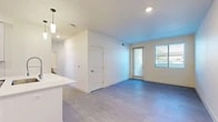 Located at 8901 Holly Ave NE in Albuquerque, New Mexico, this single-story, 2-bedroom, 1-bathroom home offers a clean, modern aesthetic throughout. The open-concept living area flows seamlessly from the kitchen into the dining and living spaces, all finished with light-toned luxury vinyl plank flooring and bright white walls that create an airy, welcoming atmosphere. Large windows and a glass patio door flood the living area with natural light. The contemporary kitchen is a standout feature, boasting stainless steel appliances — including a gas range, microwave, refrigerator, and dishwasher — paired with two-tone cabinetry, white quartz countertops, a tile backsplash, and a large kitchen island with a deep-basin sink and pendant lighting. Both bedrooms are well-proportioned and bright, each with light flooring and ceiling fans or ample lighting. The primary bedroom includes a spacious walk-in closet with built-in shelving and hanging rods. The full bathroom features a stylish vanity with quartz countertop, a framed mirror, and a glass-enclosed walk-in shower with tile surround. Additional highlights include a dedicated laundry area, a private patio, and generous closet storage throughout.