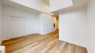 Located at 1245 N Anchor Way in Portland, Oregon, this thoughtfully designed studio unit offers a clean, modern aesthetic throughout its efficiently organized single-floor layout. Light wood-tone flooring flows seamlessly across every room, complementing the crisp white walls and recessed lighting that keep the space feeling bright and airy.

The open-concept kitchen and living area serves as the heart of the unit. The kitchen is outfitted with sleek gray cabinetry, white countertops, a subway tile backsplash, and a full suite of stainless steel appliances including a refrigerator, electric range, microwave, and dishwasher. A dedicated in-unit stacked washer and dryer is conveniently tucked alongside the kitchen, adding a practical touch. The living area benefits from soaring clerestory windows that flood the space with natural light and frame views of the nearby marina, creating a serene, waterfront ambiance.

The bathroom is clean and well-appointed, featuring a full soaking tub with shower, matte black fixtures, a gray vanity with a white countertop, and matching wood-tone flooring. A closet provides additional storage. The overall design is contemporary and cohesive, making excellent use of the available space while maintaining an open, comfortable feel throughout.